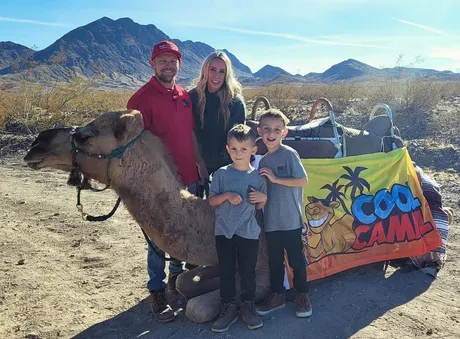 The Cool Camel family posing with a camel in the Nevada desert